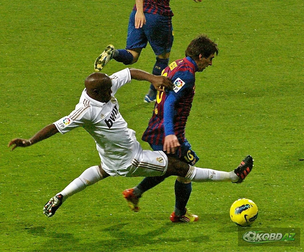 Lassana Diarra của Real Madrid xoạc bóng trước Lionel Messi trong trận El Clásico