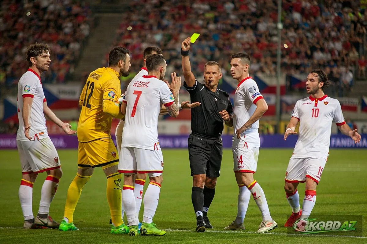 Trọng tài giơ thẻ vàng giữa vòng vây cầu thủ Montenegro ở vòng loại EURO 2020