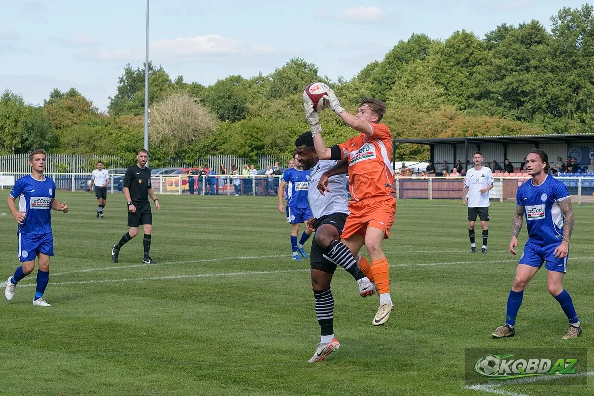 Thủ môn Mikey Shorthouse của Hanley Town bật cao bắt bóng trước tiền đạo Lichfield City
